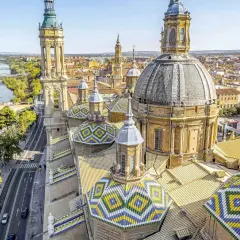 Vistas aéreas de la Basílica del Pilar en Zaragoza, con el río Ebro y puentes. Imagina un viaje en tren Sevilla Zaragoza para ver esta maravilla.