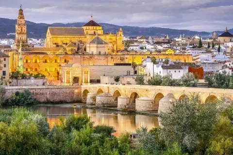 Puente Romano y Mezquita-Catedral de Córdoba, un ave que vuela sobre la historia, evocando un viaje desde Barcelona.